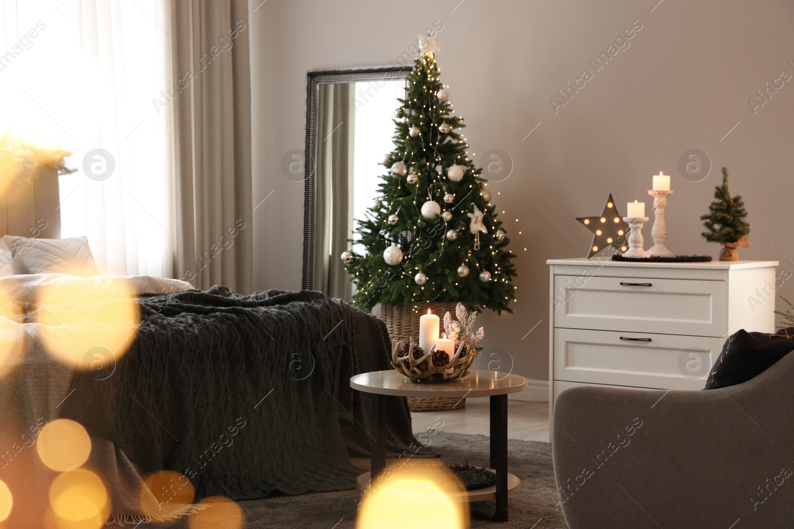 Photo of Beautiful decorated Christmas tree with fairy lights in bedroom interior