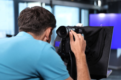 Professional video camera operator working in studio, closeup