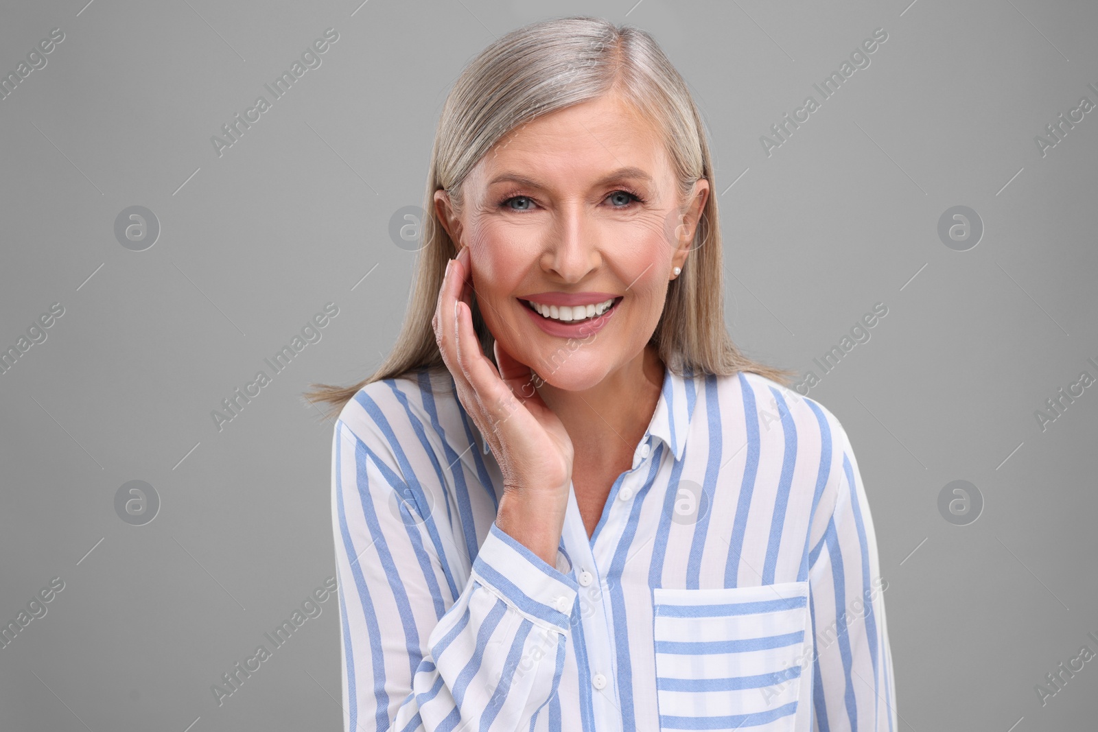 Photo of Portrait of beautiful middle aged woman on light grey background