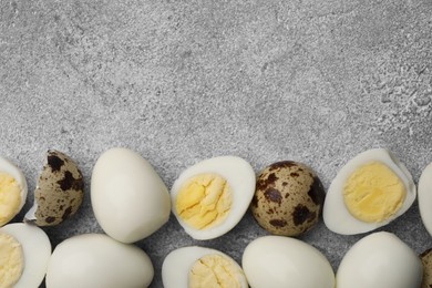 Photo of Peeled and unpeeled hard boiled quail eggs on grey table, flat lay. Space for text
