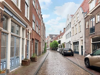 Photo of Picturesque view of city street with beautiful buildings and parked cars