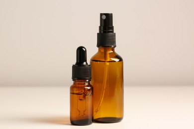 Photo of Bottles with oil on white table. Natural cosmetics