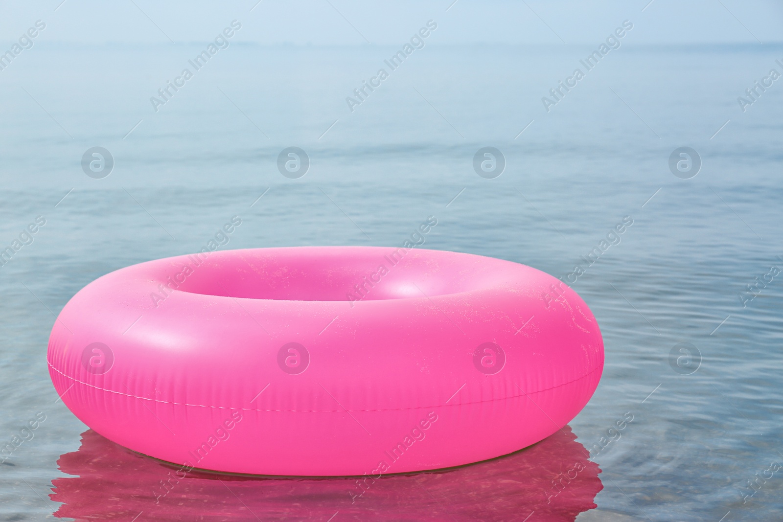 Photo of Bright inflatable ring floating on sea water. Summer vacation