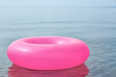 Photo of Bright inflatable ring floating on sea water. Summer vacation