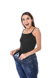 Slim woman in oversized jeans on white background. Weight loss