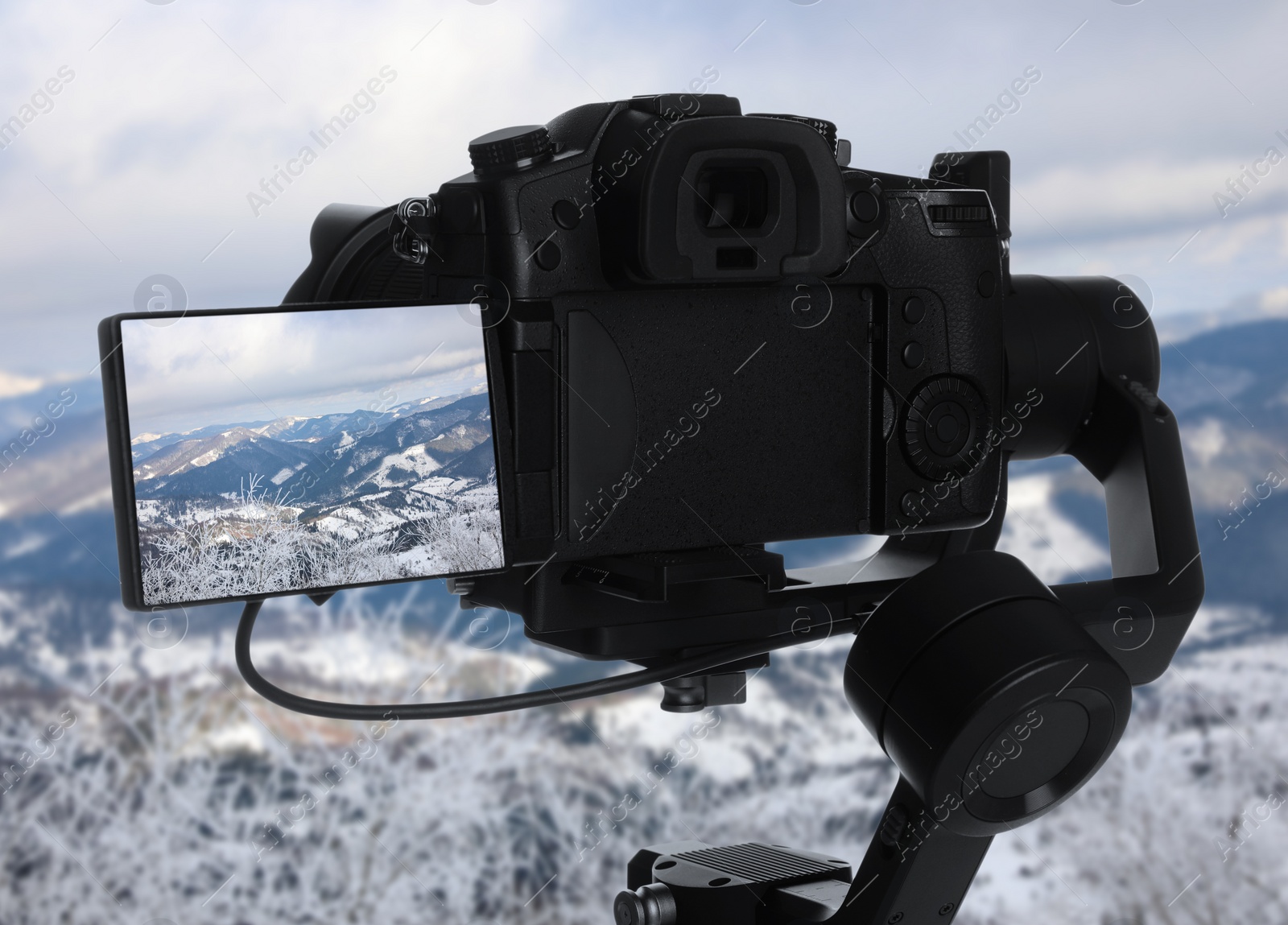 Image of Recording beautiful view of snowy mountains on professional video camera