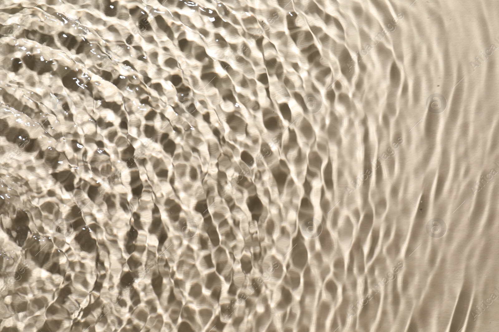 Photo of Rippled surface of clear water on beige background, top view