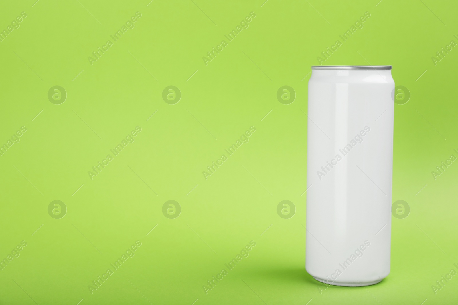 Photo of White can of energy drink on green background. Space for text