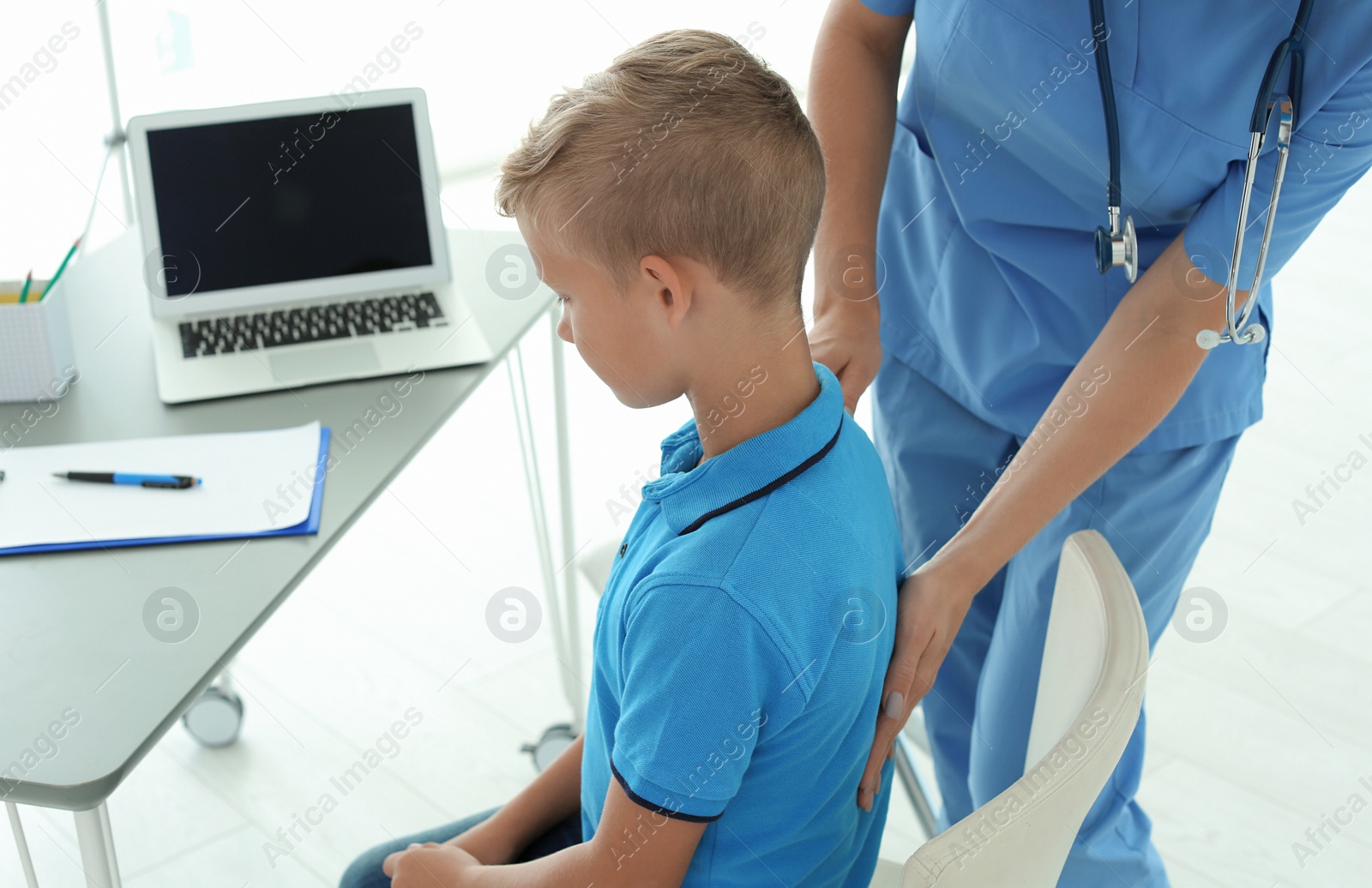 Photo of Female medical assistant examining child in clinic