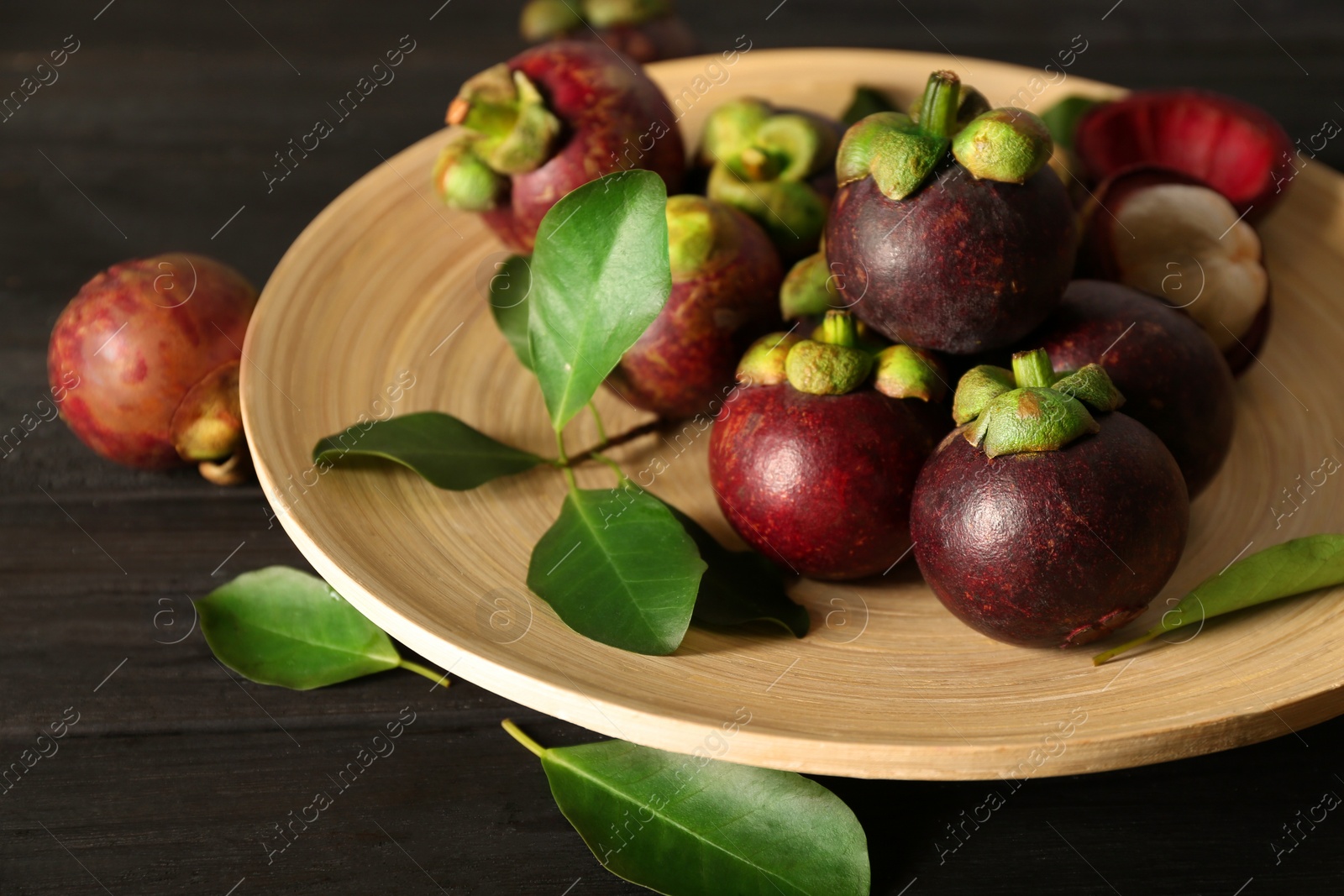 Photo of Fresh ripe mangosteen fruits on dark wooden table