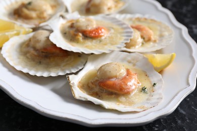 Photo of Fried scallops in shells and lemon on table, closeup