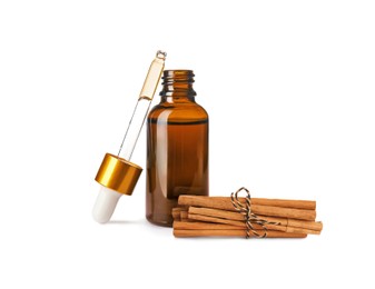 Image of Bottle of natural essential oil and dry cinnamon sticks on white background