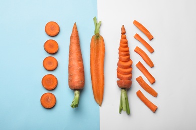 Flat lay composition with fresh sliced carrots on color background