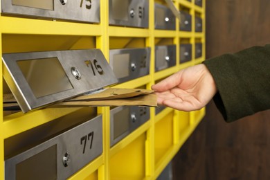 Photo of Woman taking envelopes out of mailbox in post office, closeup