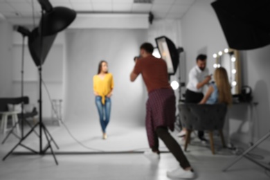 Photo of Blurred view of professional team working with model in photo studio