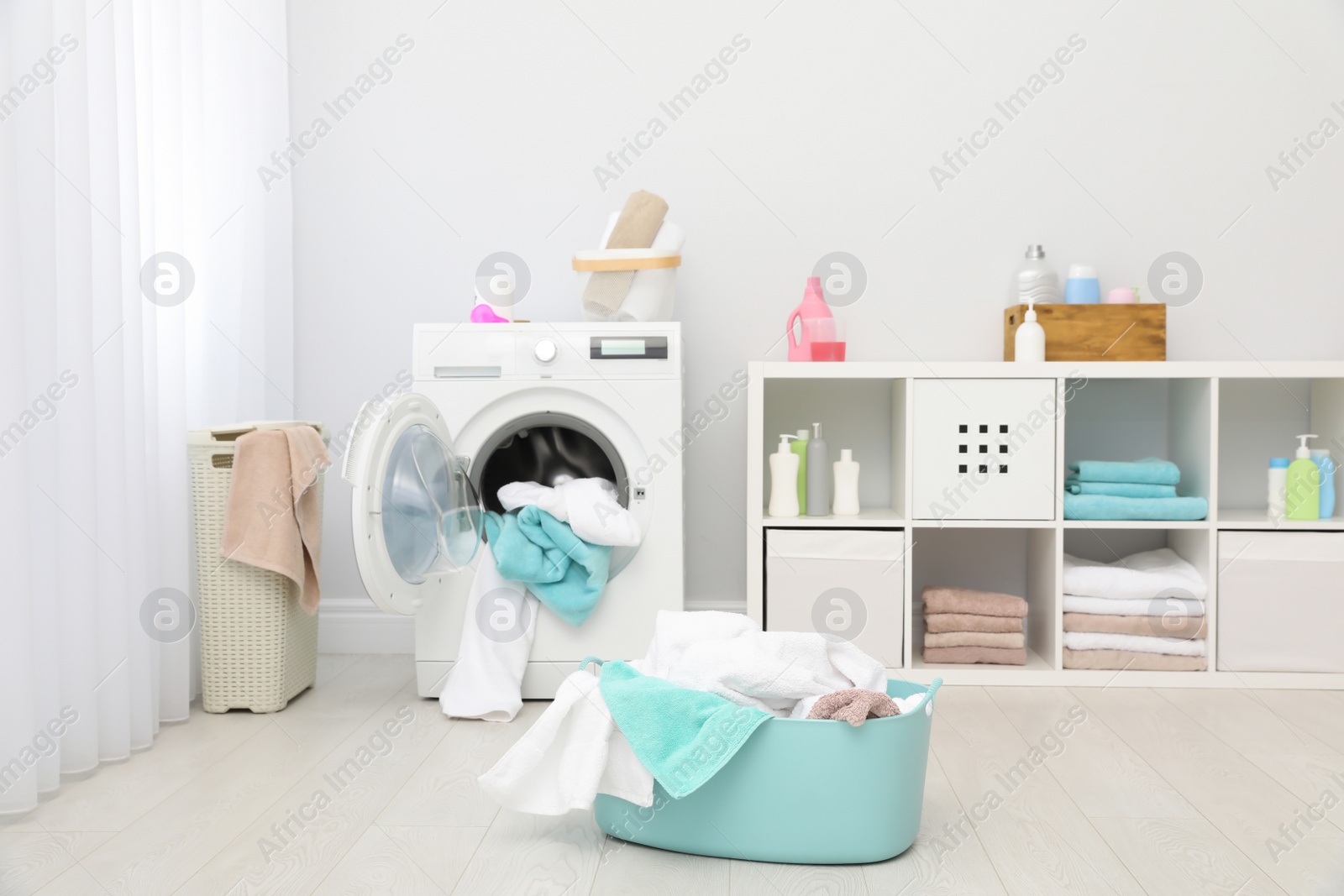 Photo of Bathroom interior with dirty towels in basket and washing machine