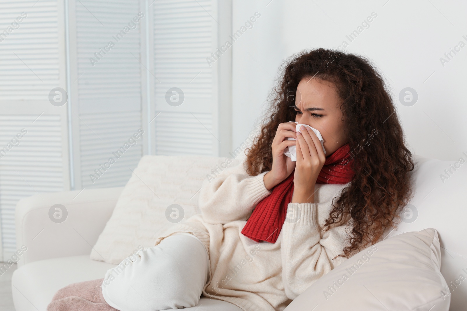 Photo of Sick African American woman with tissue at home