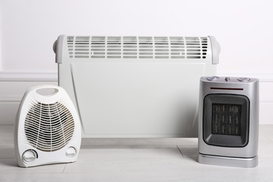 Photo of Three different electric heaters on floor in room