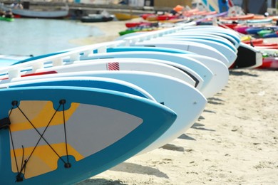 Photo of Many paddle boards on sand near sea