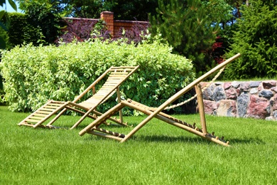 Photo of Wooden deck chairs in beautiful garden on sunny day