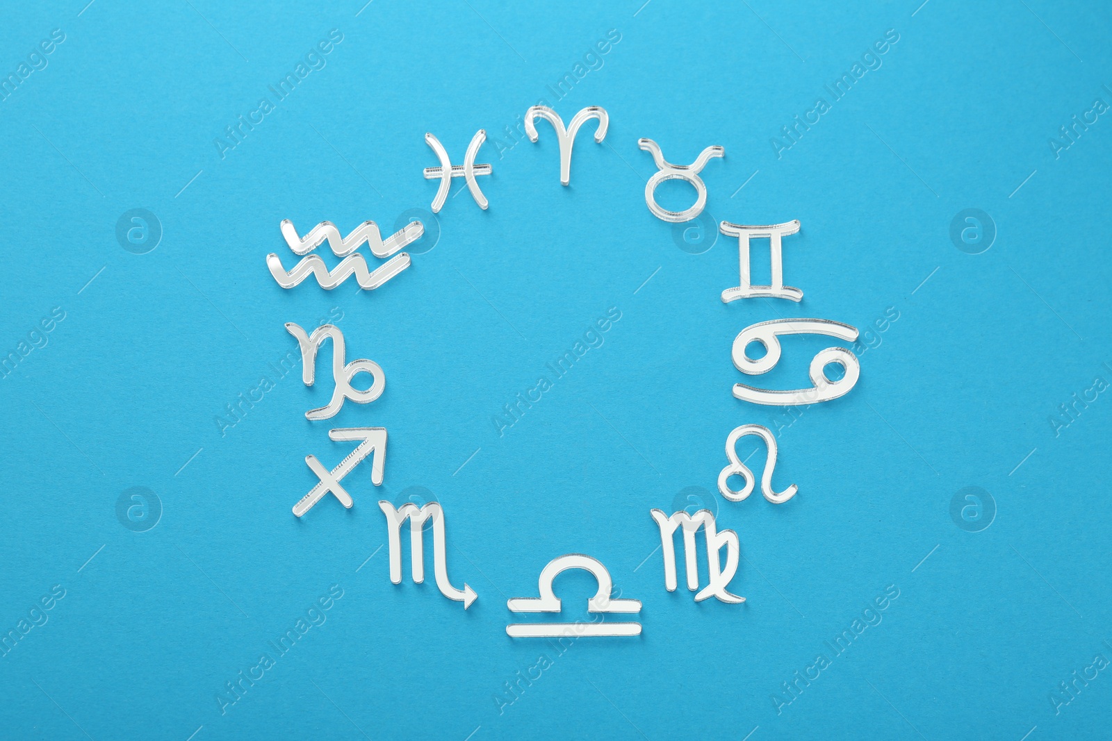 Photo of Zodiac signs on light blue background, flat lay