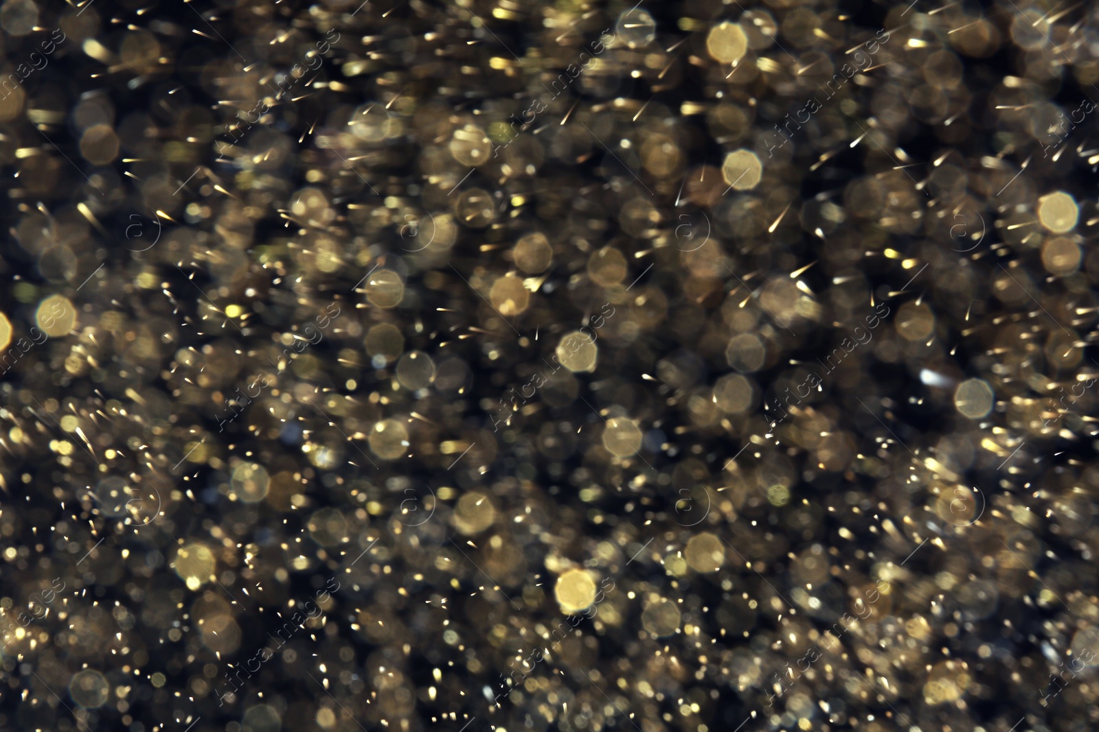 Photo of Golden glitter with bokeh effect on dark background