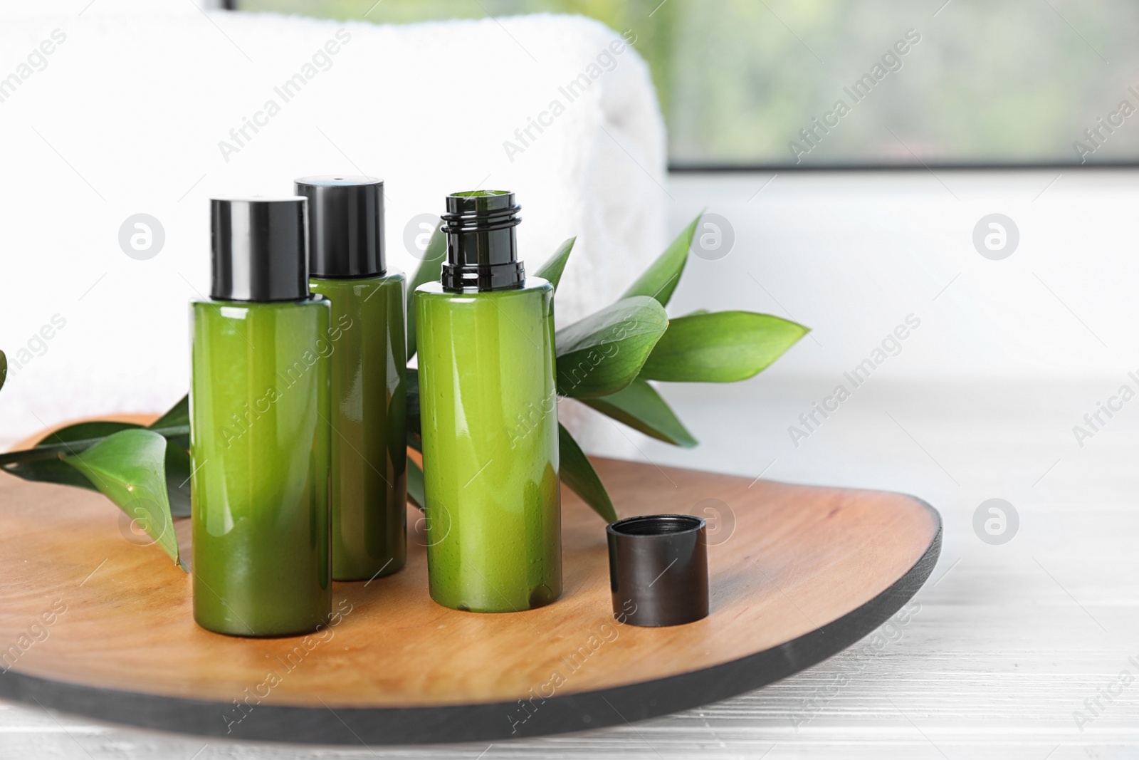 Photo of Composition with mini bottles of cosmetic products on white wooden window sill