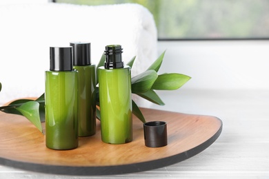 Composition with mini bottles of cosmetic products on white wooden window sill