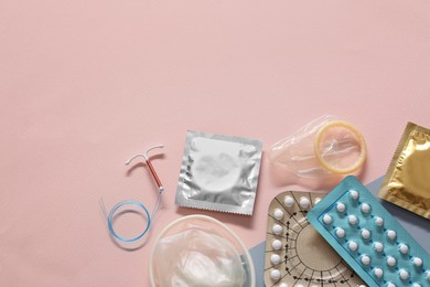 Contraceptive pills, condoms and intrauterine device on beige background, flat lay with space for text. Different birth control methods