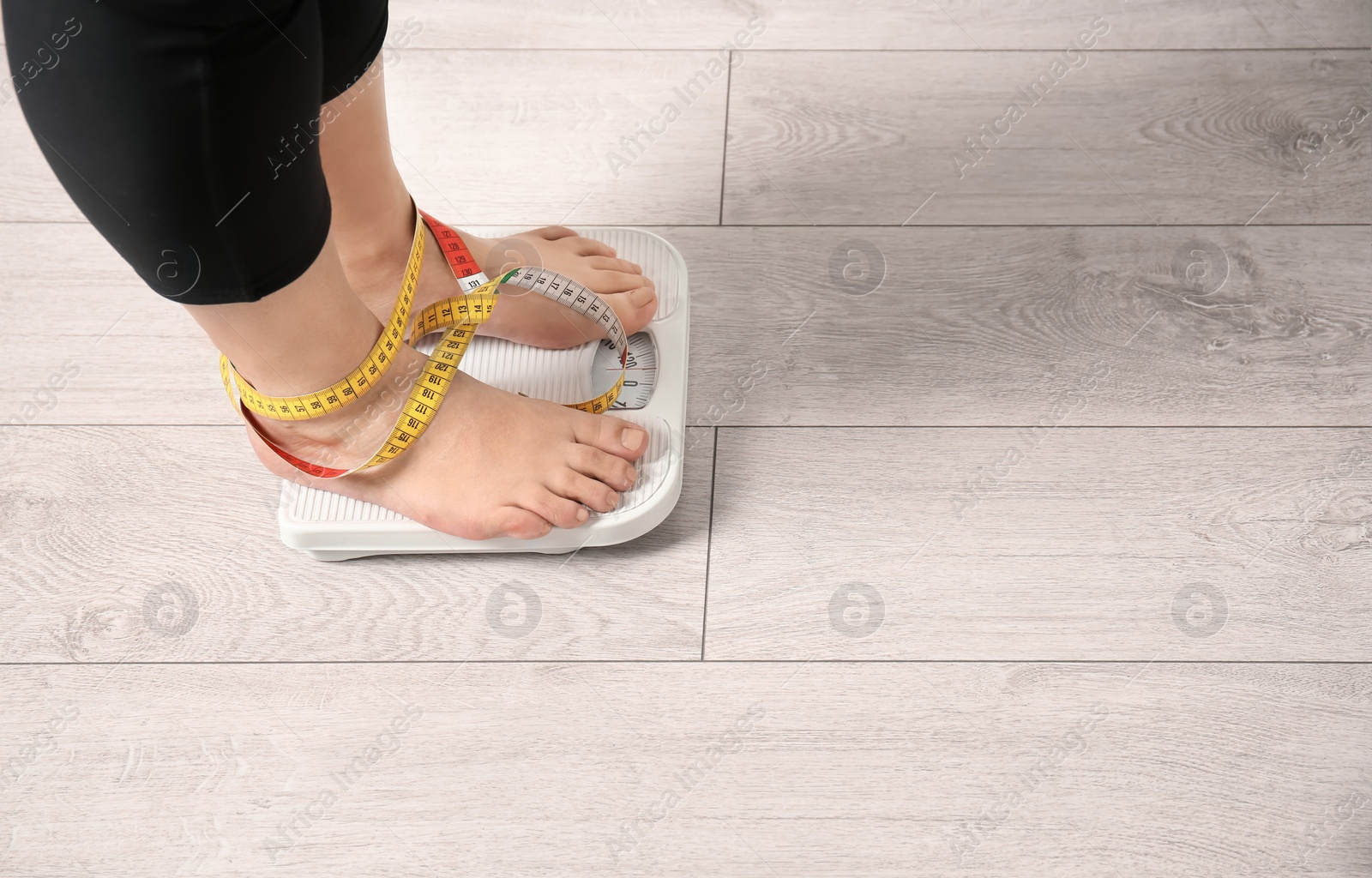 Photo of Overweight woman using scales indoors