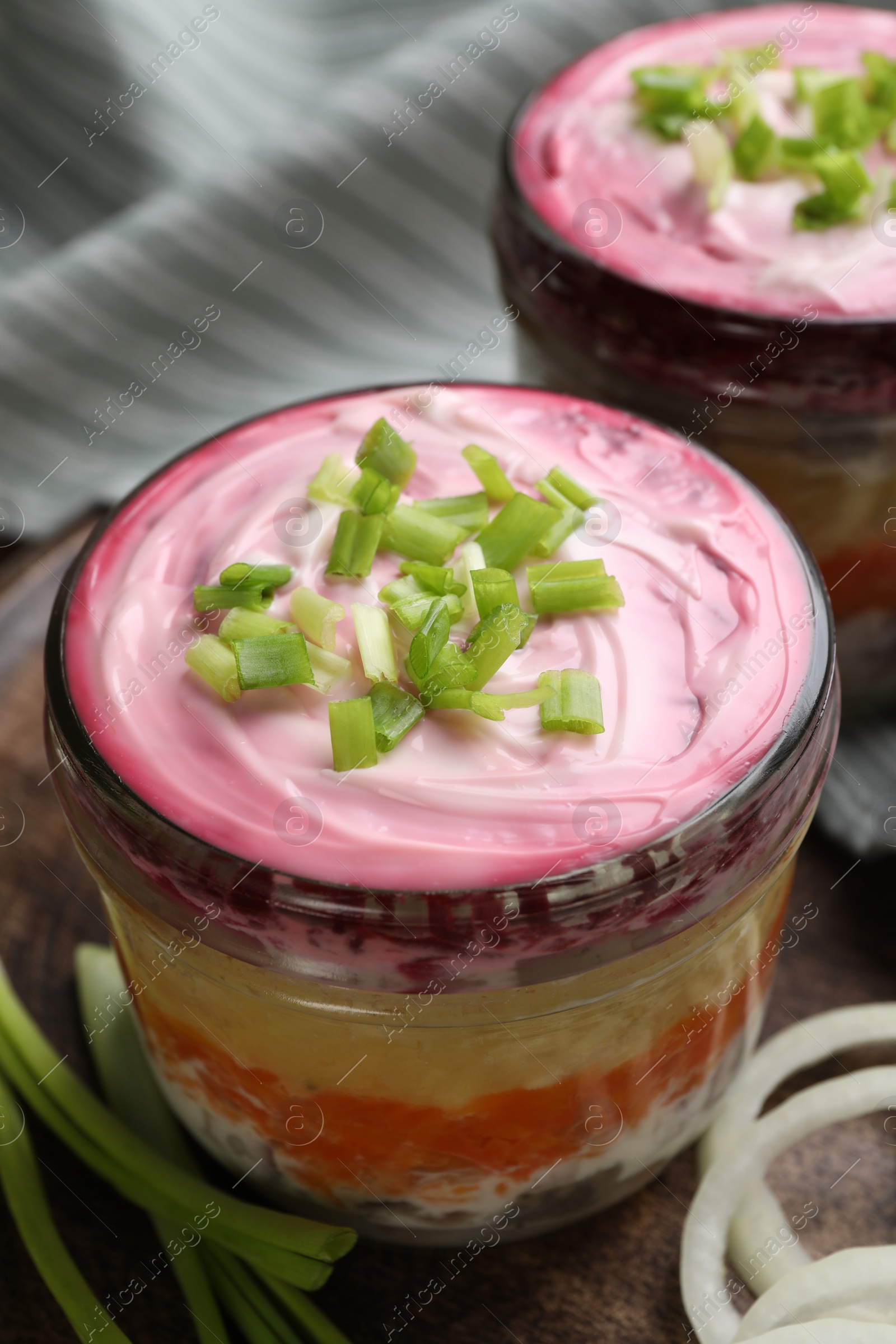 Photo of Glass jars of herring under fur coat, closeup. Traditional Russian salad