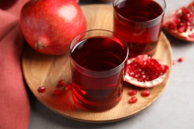 Photo of Pomegranate juice and fresh fruits on grey table