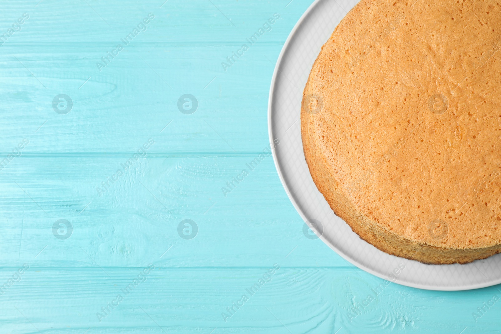 Photo of Delicious fresh homemade cake on light blue wooden table, top view. Space for text