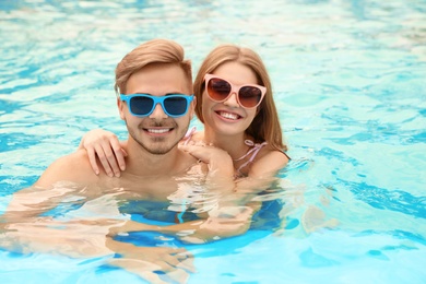 Young couple in pool on sunny day