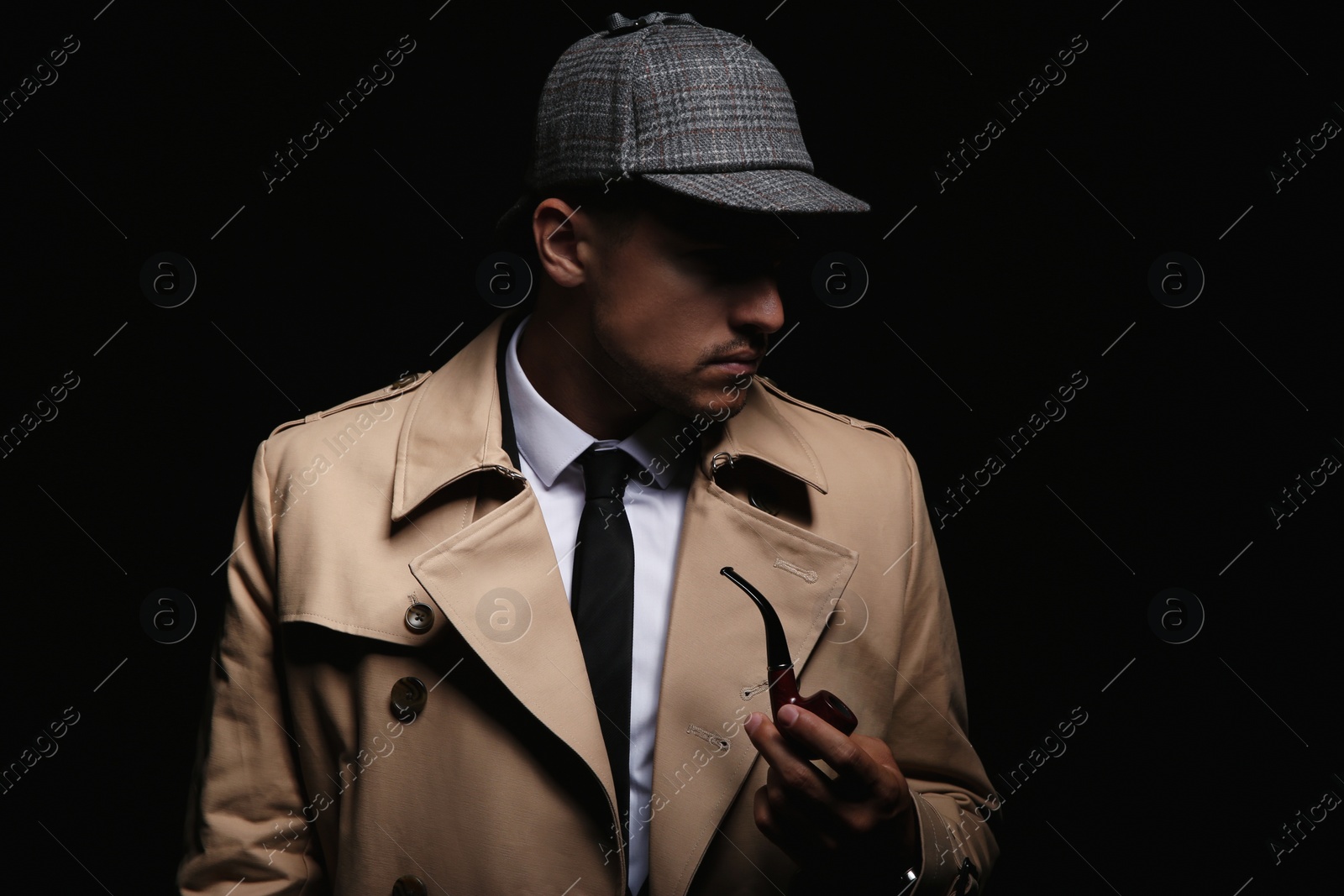 Photo of Old fashioned detective with smoking pipe on dark background