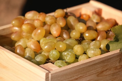 Photo of Fresh ripe juicy grapes in wooden crate, closeup