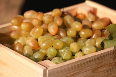 Fresh ripe juicy grapes in wooden crate, closeup