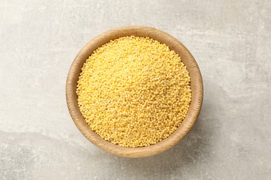 Photo of Millet groats in bowl on light grey table, top view