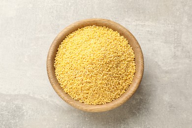 Millet groats in bowl on light grey table, top view