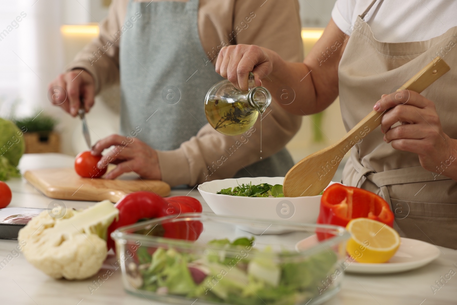 Photo of Senior couple cooking together in kitchen, closeup