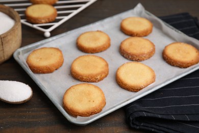 Photo of Tray with tasty sweet sugar cookies on wooden table, closeup