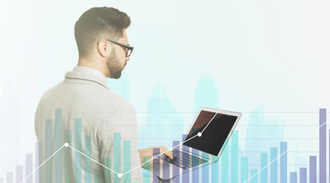 Double exposure of businessman with laptop and cityscape. Forex trading