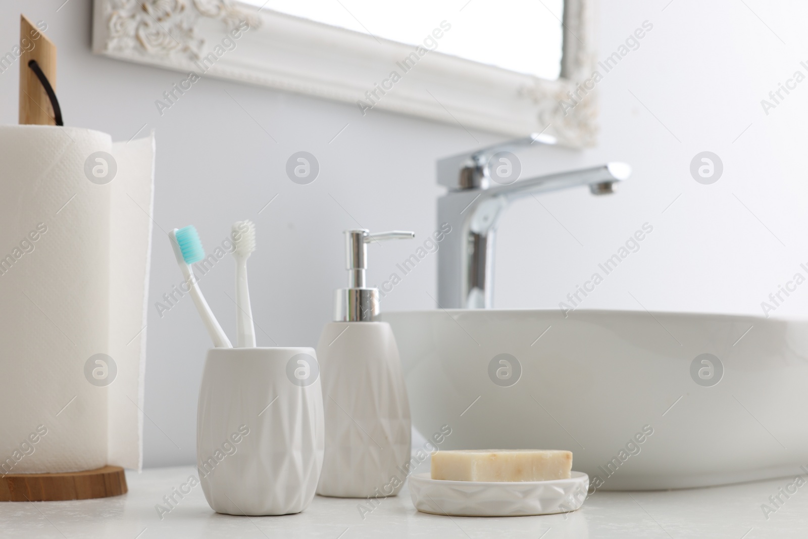 Photo of Different bath accessories and personal care products near sink on bathroom vanity