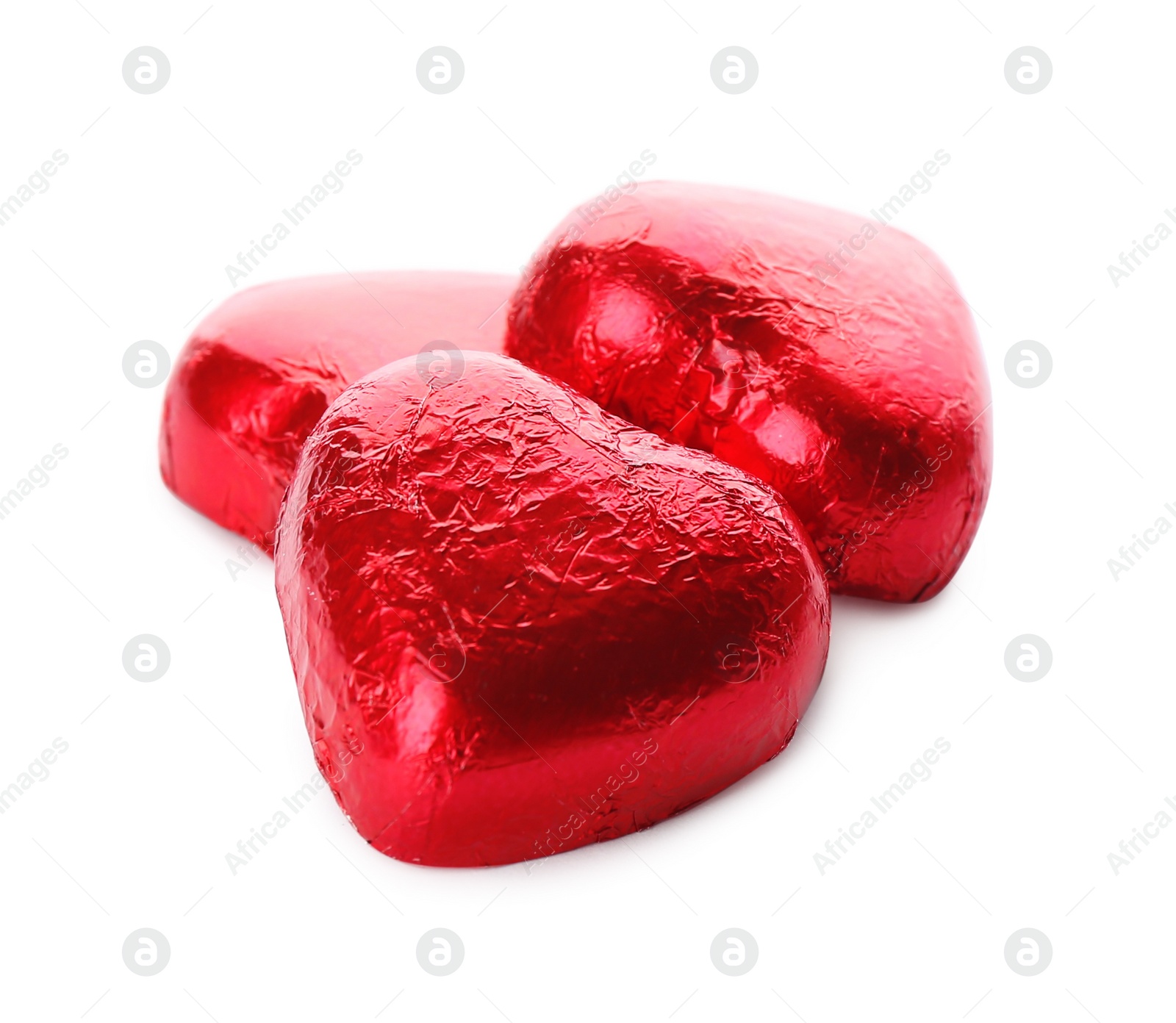 Photo of Heart shaped chocolate candies in red foil on white background