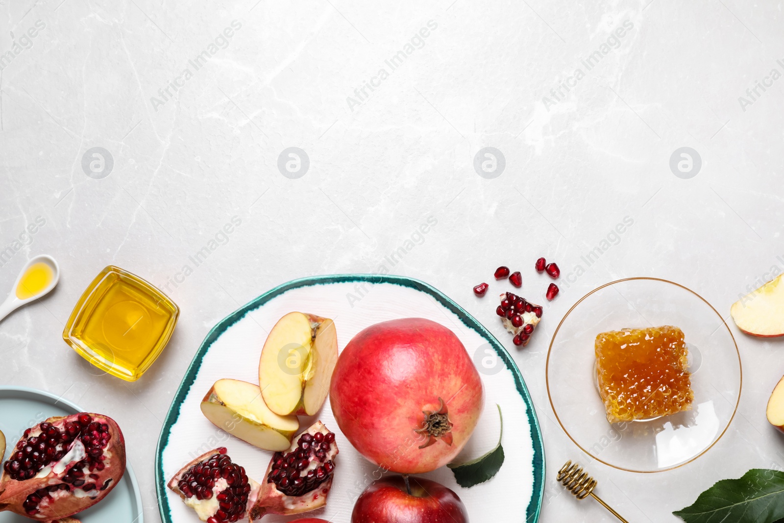 Photo of Honey, apples and pomegranates on white table, flat lay with space for text. Rosh Hashanah holiday