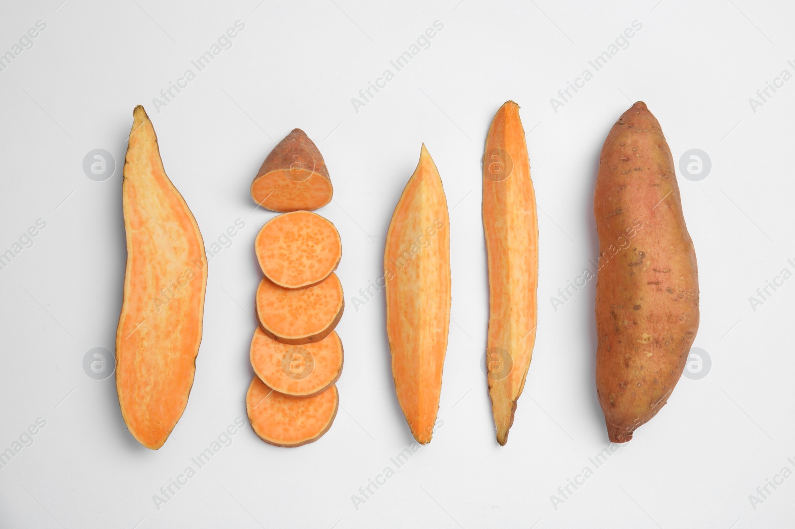 Photo of Cut and whole sweet potatoes on white background, top view