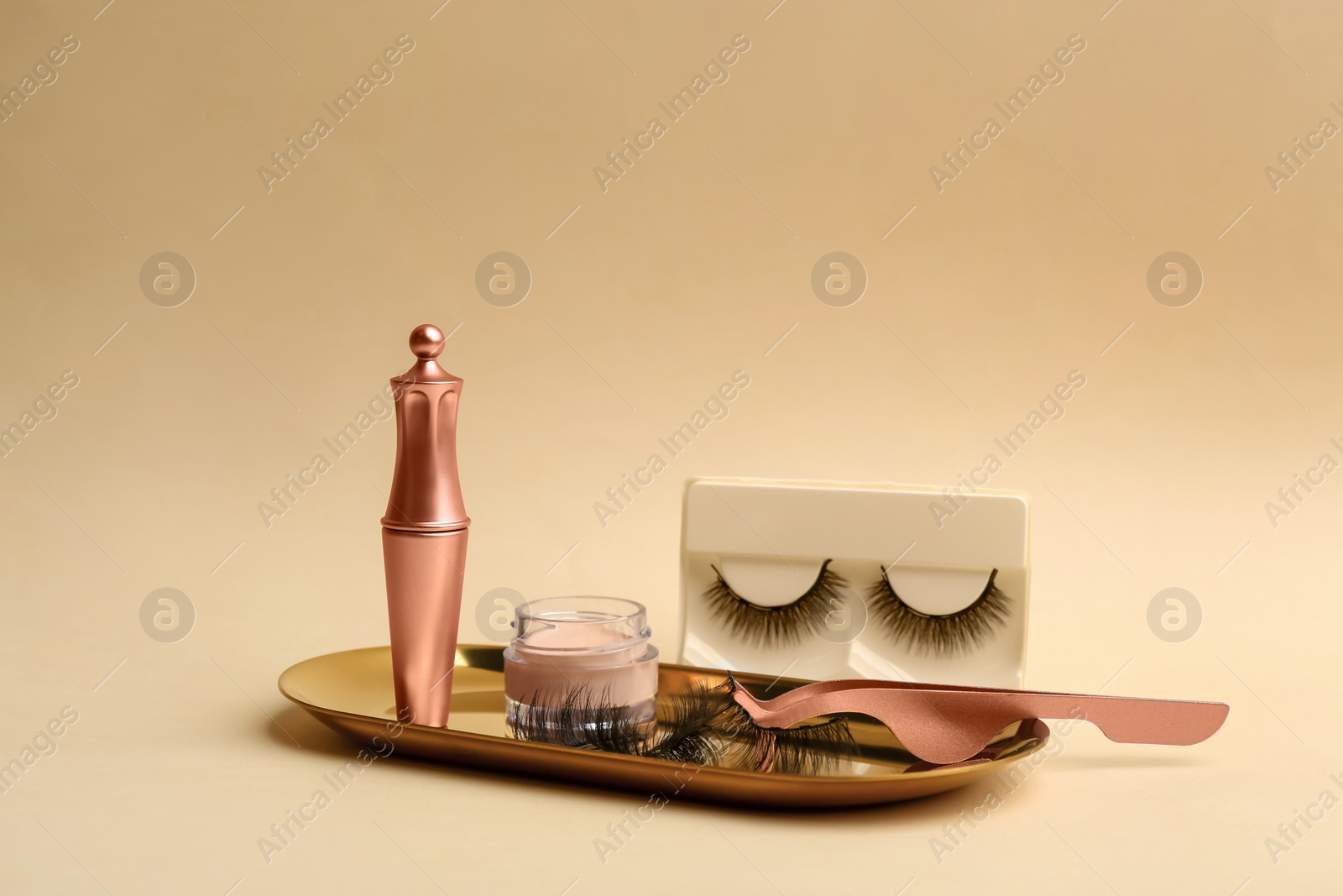 Photo of Magnetic eyelashes and accessories on beige background