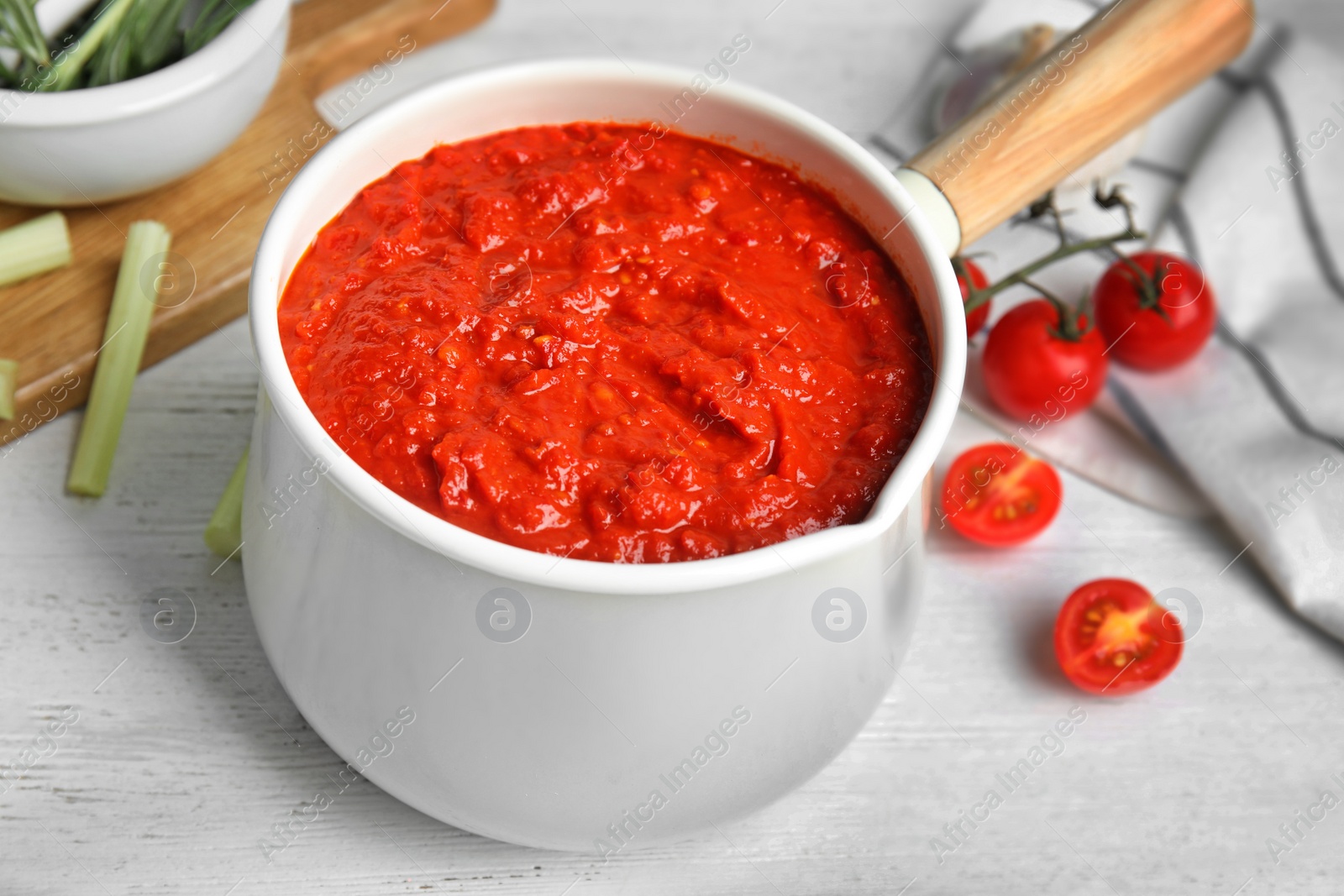 Photo of Delicious tomato sauce in pan on white wooden table, closeup