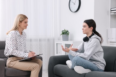 Psychologist working with teenage girl in office