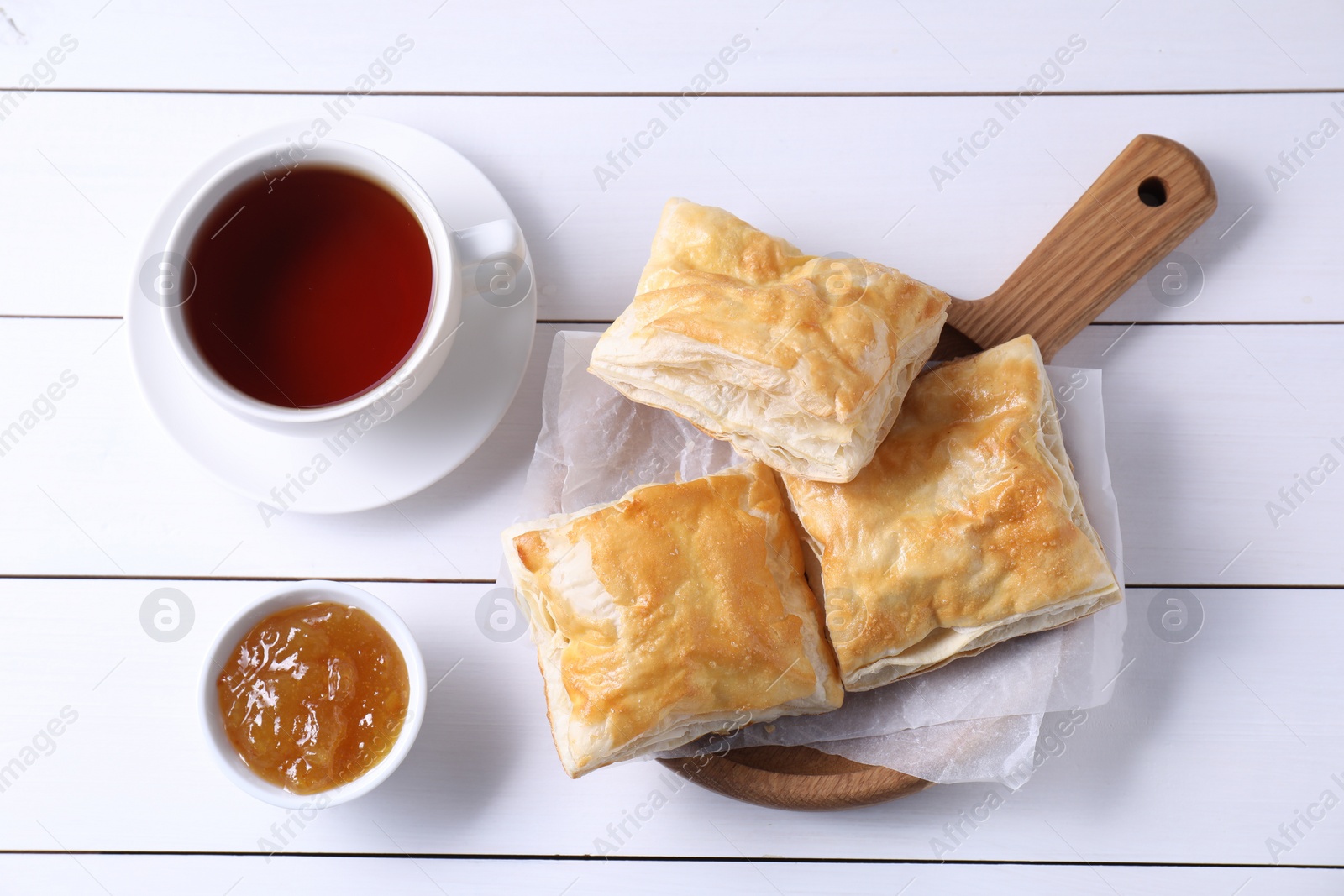 Photo of Delicious puff pastry served on white wooden table, flat lay